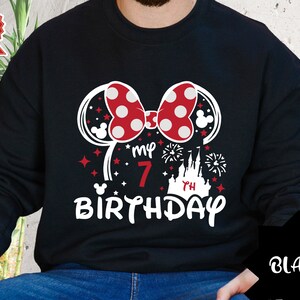May include: Black sweatshirt with a red and white Minnie Mouse ears design, the text "my 7th birthday" and a silhouette of Cinderella's castle.