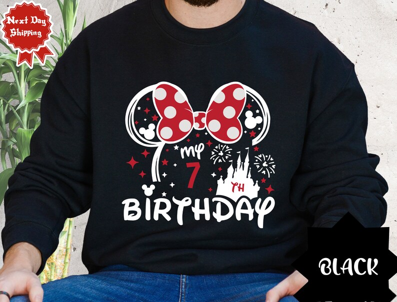 May include: Black sweatshirt with a red and white Minnie Mouse ears design, the text "my 7th birthday" and a silhouette of Cinderella's castle.