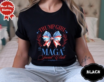 May include: Black t-shirt with a red, white, and blue bow with stars and the text "Trump Girl 45* MAGA *47 Social Club".