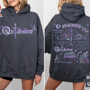 K&ouml;nnte beinhalten: Dunkelgrauer Kapuzenpullover mit dem Wort "Quicksilver" in einer stilisierten Schrift auf der Vorderseite. Die R&uuml;ckseite zeigt das Wort "Kingfisher" und Illustrationen von Schwert, Bergen und Wolf. Der Hoodie hat eine Vordertasche.