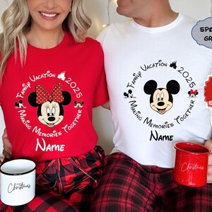 May include: Coordinating red and white t-shirts featuring Mickey and Minnie Mouse designs, ideal for a family holiday in 2025. The shirts display the text "Family Vacation Making Memories Together" and "Name". Each person holds a mug with the word "Christmas".