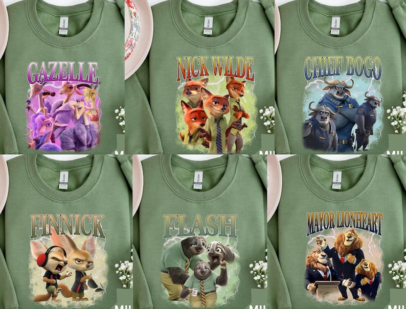 May include: Sage green sweatshirts featuring characters from the animated movie Zootopia. Each sweatshirt displays a different character's name and image: Gazelle, Nick Wilde, Chief Bogo, Finnick, Flash, and Mayor Lionheart. The designs are colorful and eye-catching.