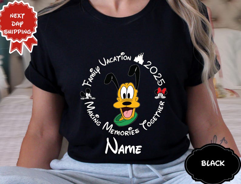 May include: Black t-shirt with a circular design featuring Pluto, Mickey, and Minnie Mouse. The design includes the text "Family Vacation 2025 Making Memories Together" and space for a name. A "Next Day Shipping" sticker is visible.