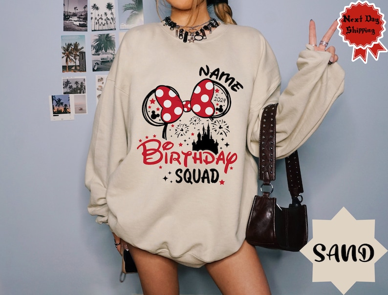 May include: A beige sweatshirt with a red and white Minnie Mouse bow, a black castle, and the text "NAME BIRTHDAY SQUAD 2021".