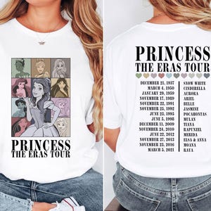 May include: White t-shirt with a graphic of Disney princesses and the text "Princess The Eras Tour". The graphic includes the princesses' names and the dates they were released.