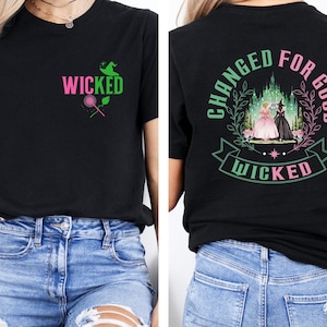 May include: Black t-shirt with the word "WICKED" in pink and green, a witch hat, and a magic wand graphic on the front. The back features a design with the words "CHANGED FOR GOOD" and "WICKED" around an image of two women in front of a castle.