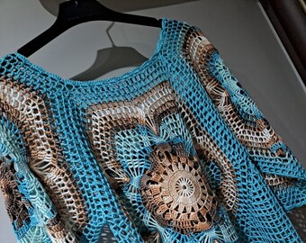 Handgefertigte Strickbluse mit Motiven und Löchern.