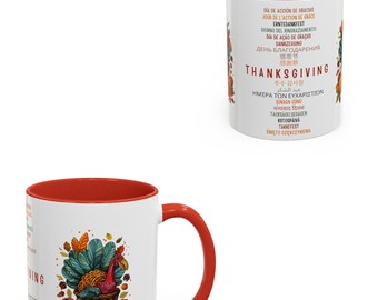 Può includere: Una tazza in ceramica bianca con bordo e manico rossi. La tazza presenta un'illustrazione colorata di un tacchino circondato da zucche, mele e foglie autunnali. Il testo "THANKSGIVING" è stampato in nero sulla tazza, insieme alla parola "THANKSGIVING" in diverse lingue.