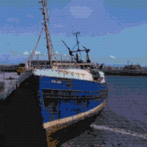 May include: A blue and white fishing boat is beached under a blue sky. The boat has a wooden mast and is painted with peeling blue paint. The boat is resting on a stony shore. The sea is visible in the background.