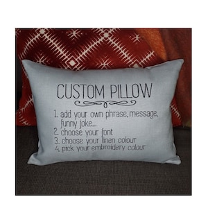 May include: A light blue pillow with the text "CUSTOM PILLOW" and instructions for customizing the pillow: 1. add your own phrase, message, funny joke... 2. choose your font 3. choose your linen colour 4. pick your embroidery colour