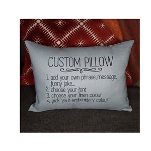 May include: A light blue pillow with the text "CUSTOM PILLOW" and instructions for customizing the pillow: 1. add your own phrase, message, funny joke... 2. choose your font 3. choose your linen colour 4. pick your embroidery colour