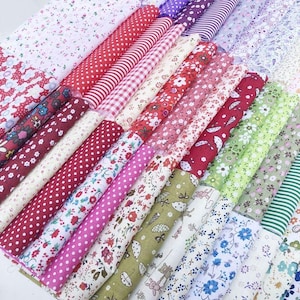 May include: A collection of rolled fabric bolts featuring various patterns. Designs include polka dots, stripes, floral, and other prints in red, pink, white, green, and purple. The fabrics are likely cotton or a similar material.