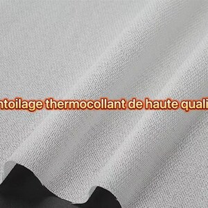 Peut inclure: Gros plan sur un tissu d'entoilage thermocollant blanc de haute qualité. Le tissu est légèrement texturé et plié, avec le texte "Entoilage thermocollant de haute qualité" en orange.