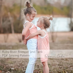 May include: Two young girls wearing matching pink rompers and tank tops, standing in a field. The outfits have a white trim and a subtle pattern. One girl wears white pants. The image includes the text "Ruby River Romper and Tank PDF Sewing Pattern" and "Ocean Code."