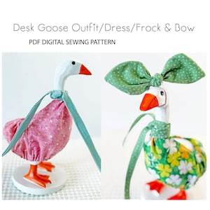 May include: Two wooden goose figurines wearing handmade outfits. One goose is dressed in a pink dress with white polka dots and a teal strap. The other goose wears a green bow and a green and yellow floral dress. Text at the top reads "Desk Goose Outfit/Dress/Frock & Bow".