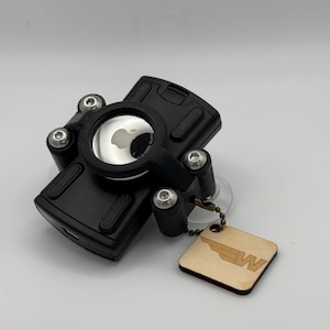 May include: Black phone holder with a clear plastic window and a small wooden tag with the letter "W" and a wing design.