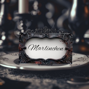 May include: A black and red ornate frame with a white background and the word "Marlinchen" written in black cursive.