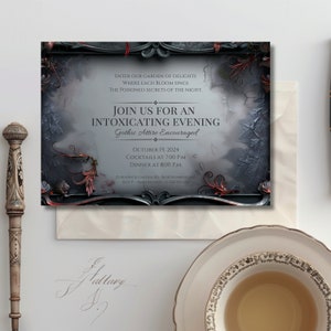 Mock up of an editable gothic dinner party invitation. 

Invitation features a black rococo frame with vivid red poisonous plants growing through it and a background of shadowy leaves.

Displayed with a cream and gold teacup and bone pen.