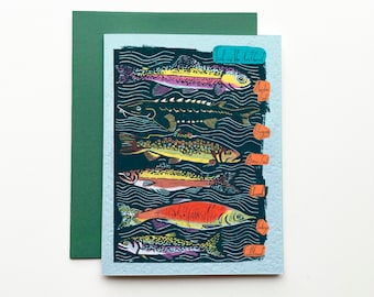 May include: Greeting card featuring colorful illustrations of various fish species, including trout and sturgeon, swimming in a stylized aquatic environment. The card has the text "Fish in the Northwest" and includes the names of the fish. A green envelope is included.