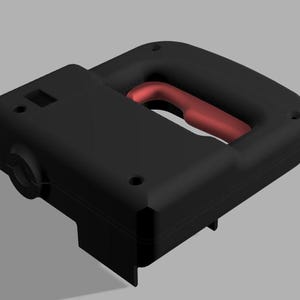 May include: A black power tool with a red handle. The tool has a rectangular body with a curved handle and several small holes. The tool is designed for cutting or shaping materials.