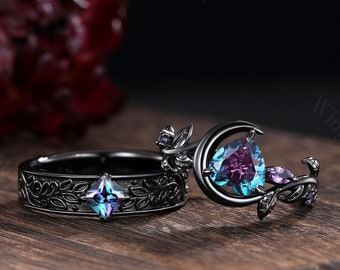 May include: A black ring set with a crescent moon design and a large, faceted, purple and blue gemstone. The other ring is a black band with a smaller, square, purple and blue gemstone.