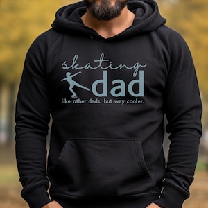 May include: A black hooded sweatshirt with the text "skating dad" and a graphic of a person ice skating. The text below the graphic reads "like other dads, but way cooler."