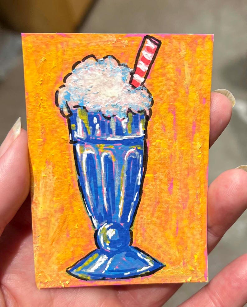 May include: A small rectangular painting featuring a blue milkshake in a tall glass with a white whipped cream topping and a red and white striped straw, set against a vibrant orange and yellow textured background with visible brushstrokes.