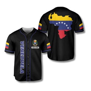 Può includere: Maglia da baseball nera con la scritta "VENEZUELA" in lettere bianche sul davanti. La maglia presenta i colori della bandiera venezuelana sulle maniche e una mappa del Venezuela sul retro. La parte anteriore ha uno stemma e uno spazio per un nome.