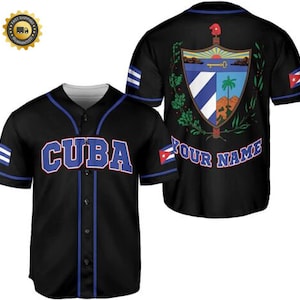 Pode incluir: Camisola de beisebol preta com guarnições azuis e a palavra "CUBA" em letras vermelhas e azuis na frente. A parte de trás da camisola apresenta o brasão de armas cubano e o texto "YOUR NAME".