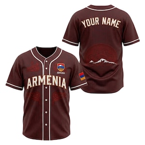 May include: A brown baseball jersey with white trim, featuring the word "Armenia" in large letters and a crest with a mountain design. The back of the jersey has the text "YOUR NAME" and a mountain graphic. The Armenian flag is also visible.