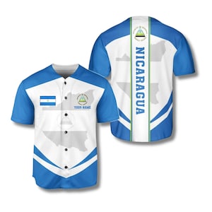 May include: A blue and white baseball jersey featuring the flag and map of Nicaragua. The jersey has blue sleeves and a white body with a map outline. The back of the jersey has the word "NICARAGUA" in blue. The front has the flag and the text "YOUR NAME".