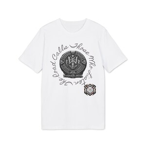 Può includere: Una t-shirt bianca a maniche corte con una grafica circolare che riporta il testo The Road Calls Those Who Listen e The Wanderer's Mark. Il design include un emblema centrale con le lettere FWR e simboli runici, oltre a una piccola icona.