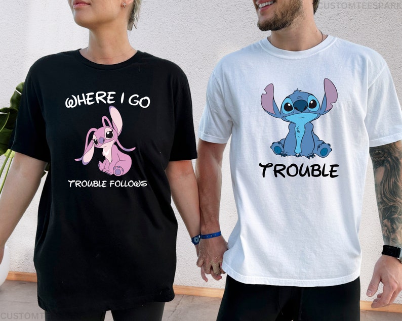May include: A couple wearing matching t-shirts with a blue and pink Stitch character. The woman's shirt says "Where I go Trouble Follows" and the man's shirt says "Trouble".