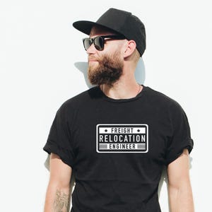 以下が含まれることがあります： 白い四角形の中に「Freight Relocation Engineer」と書いてある、黒いTシャツです。