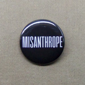 May include: A black button with the word "MISANTHROPE" printed in white.