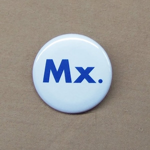 May include: A white button with the text "Mx." in blue lettering.