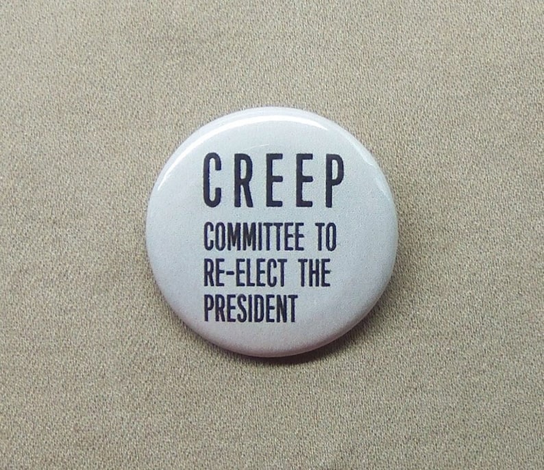 May include: White button with black text that reads "CREEP COMMITTEE TO RE-ELECT THE PRESIDENT".