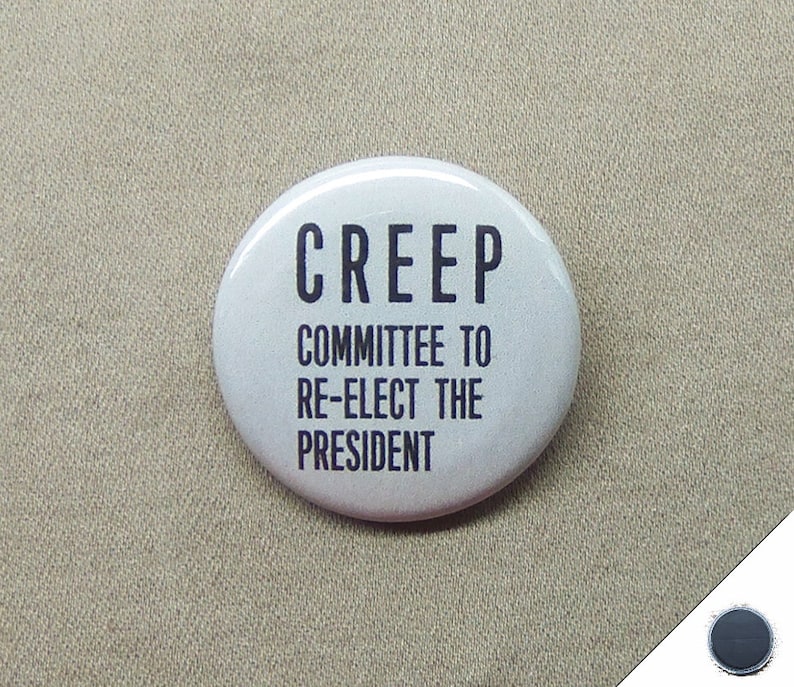 May include: A white button with black text that reads "CREEP COMMITTEE TO RE-ELECT THE PRESIDENT".