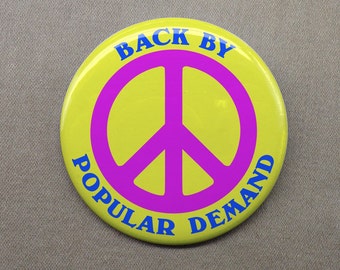 May include: Yellow button with a pink peace sign and the text "Back by Popular Demand" in blue.