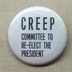 May include: White button with black text that reads "CREEP COMMITTEE TO RE-ELECT THE PRESIDENT".