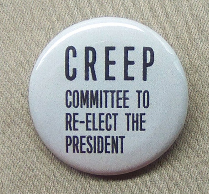 May include: White button with black text that reads "CREEP COMMITTEE TO RE-ELECT THE PRESIDENT".