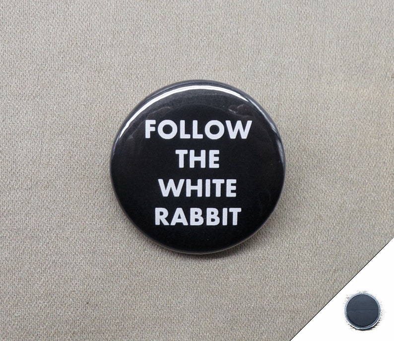 May include: A black button with white text that reads "FOLLOW THE WHITE RABBIT".
