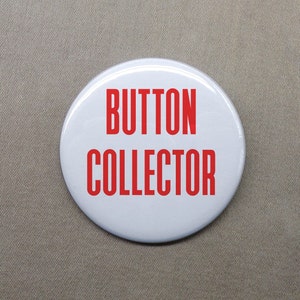 May include: White button with red text that reads "BUTTON COLLECTOR".
