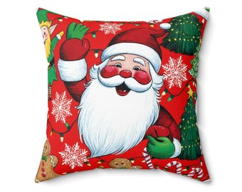 Puede incluir: Cojín cuadrado con temática navideña con fondo rojo. Presenta a Papá Noel, un elfo, copos de nieve, árboles de Navidad, hombres de jengibre y bastones de caramelo. Papá Noel lleva un gorro y guantes rojos, saludando con un guante verde. Una decoración festiva.