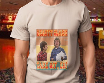 May include: A beige t-shirt with a vintage-style graphic featuring two men. The graphic says "Beauty Clark" and "Take Off, Eh!" in red and yellow text.