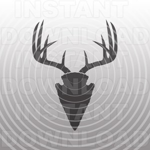 May include: A grayscale graphic featuring a deer antler silhouette atop an arrowhead design. The antlers are detailed with multiple tines, and the arrowhead is pointed. The background has a radial pattern with the words "INSTANT DOWNLOAD" repeated.