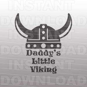 Może przedstawiać: Czarno-biała sylwetka hełmu wikinga z rogami i tekstem "Daddy's Little Viking" poniżej.