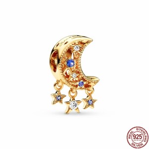 Puede incluir: Encanto dorado con forma de luna creciente con cristales azules y blancos, y tres encantos de estrella colgantes con cristales azules y blancos.