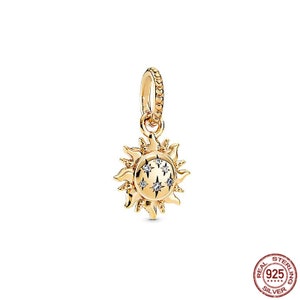 Puede incluir: Un charm de oro en forma de sol con peque&ntilde;as piedras transparentes engastadas en los rayos del sol. El charm est&aacute; dise&ntilde;ado para ser a&ntilde;adido a una pulsera o collar.