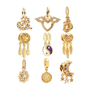 Puede incluir: Nueve colgantes de amuleto de oro con varios dise&ntilde;os, que incluyen un coraz&oacute;n con alas, un atrapasue&ntilde;os, un sol, una luna, una linterna, un s&iacute;mbolo yin yang y un coraz&oacute;n con plumas. Los amuletos est&aacute;n hechos de oro y tienen detalles intrincados.